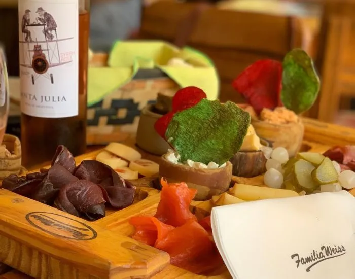 Picada de ahumados con vino tinto sobre tabla de madera